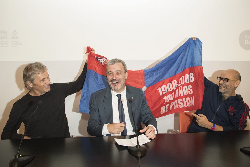 FOTO EFE. Mortensen y el poeta Fabián Casas muestran la bandera del club argentino al alcalde de Cultura de Barcelona, Jaume Collboni