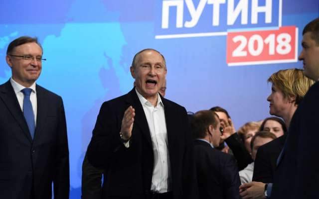 Presidential candidate, President Vladimir Putin speaks as he meets with confidants at his campaign headquarters in Moscow on March 18, 2018. / AFP PHOTO / Yuri KADOBNOV
