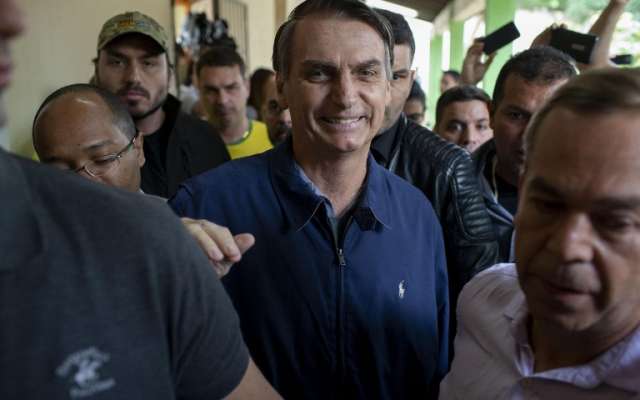 El candidato presidencial de derecha de Brasil para el Partido Social Liberal (PSL), Jair Bolsonaro (C), se retira luego de emitir su voto durante las elecciones generales, en Río de Janeiro, Brasil, el 7 de octubre de 2018. Foto: AFP /Mauro Pimentel