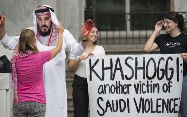 Un manifestante vestido como el príncipe heredero de Arabia Saudita Mohammed bin Salman (C) con sangre en sus manos protesta con otros fuera de la Embajada de Arabia Saudita en Washington, DC, el 8 de octubre de 2018, exigiendo justicia por el desaparecido periodista Jamal Khashoggi. Foto: AFP