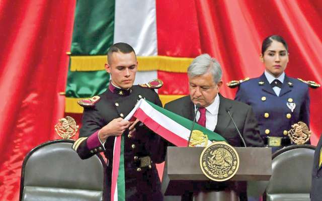 Geovanni Lizárraga, del Heroico Colegio Militar (izquierda), ayudó a colocar la banda presidencial a López Obrador. Foto: Especial.