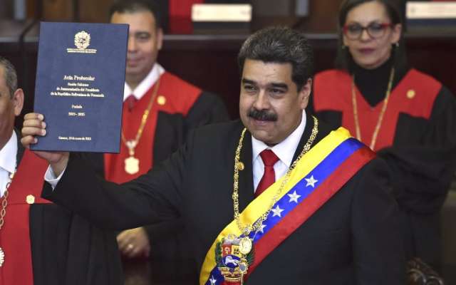 El presidente de Venezuela, Nicolás Maduro, muestra el certificado de protocolo de la ceremonia de inauguración en la sede del TSJ. Foto: AFP.