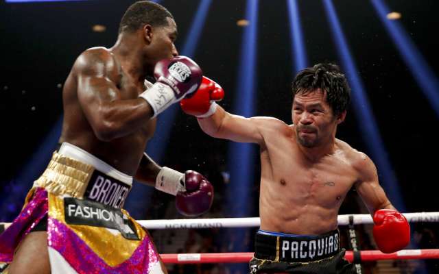 Manny Pacquiao lanza un derechazo a Adrien Broner en la pelea por el título del peso welter. FOTO: AP