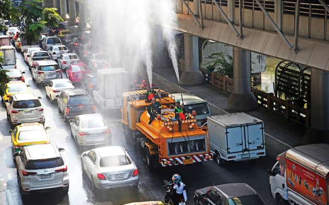 Los equipos de carreteras de Bangkok rocían agua con la esperanza de controlar el esmog.