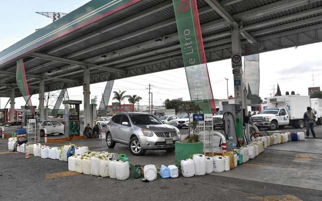 Usuarios hacen filas con bidones en una gasolinera de Toluca.