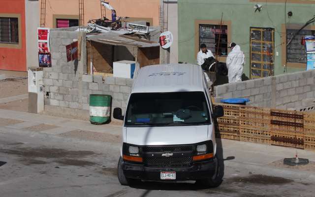 Peritos forenses trabajan en la vivienda donde fueron asesinados cinco integrantes de una familia.