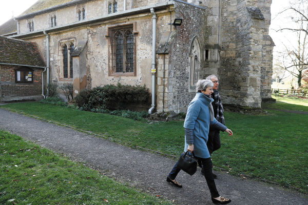 CRISIS. La premier May se retira con su esposo después de asistir a un servicio religioso. Foto: AFP