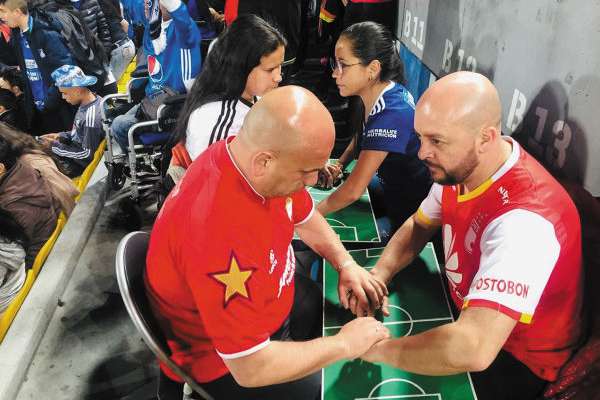 AMOR. César le narra un partido a una pareja de sordociegos. Foto: Especial