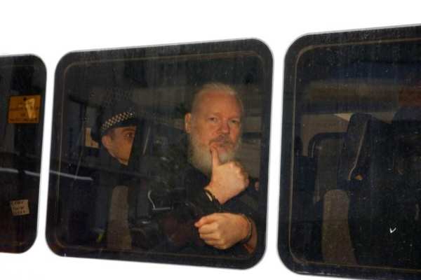 Fotógrafos y periodistas rodearon el vehículo de seguridad donde iba Julian para capturar las primeras imágenes. Foto: Reuters