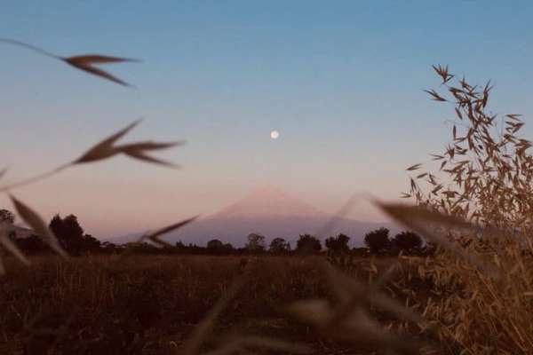 El Volcán Popocatépetl con la Luna rosa sobre él.FOTO: ESPECIAL
