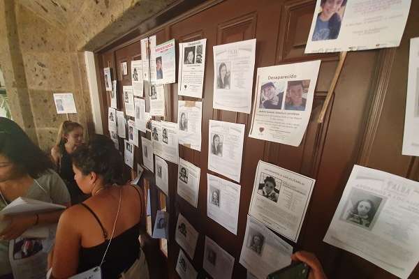 Al no recibir respuesta a su petición, pintaron consignas en el exterior de la fachada en Casa Jalisco, mientras otras personas golpeaban y rompían la madera en la puerta principal. Foto: Especial