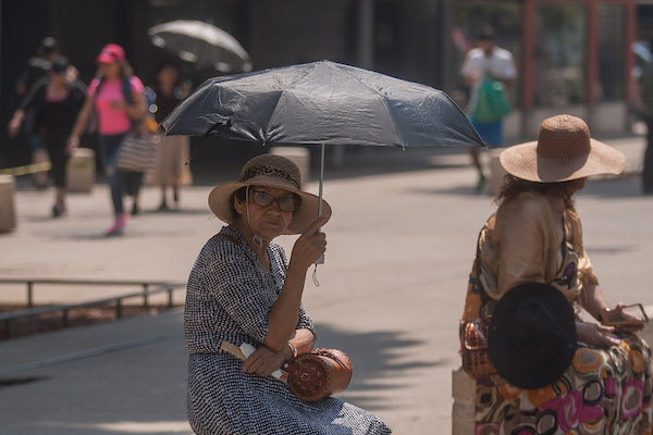 Personas se cubren del sol
