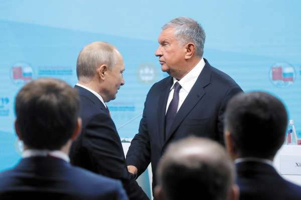 El mandatario ruso, Vladimir Putin, saluda al director ejecutivo de Rosneft, Igor Sechin. Foto: Reuters