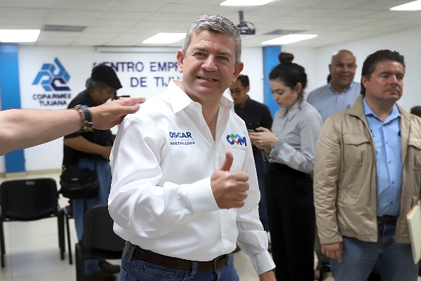 Óscar Vega Marín saludando a cámara en lugar con más gente