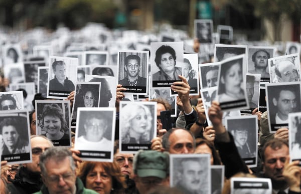 MEMORIA. Centenares de personas mostraron fotografías con los rostros de las víctimas. Foto: REUTERS.