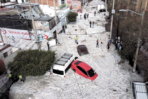 AFECTACIÓN. Varios vehículos quedaron semisumergidos entre el agua y el hielo. Foto: AFP