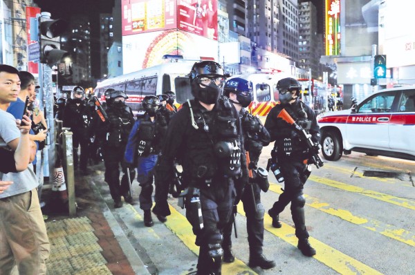 CAOS. Policías antimotines tomaron las calles tras actos de vandalismo en varios distritos de Hong Kong. Foto: REUTERS