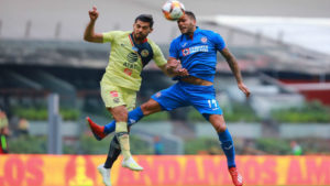 Dos jugadores de fútbol golpeando un balón