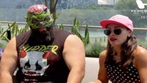 Luchador con máscara y chica con gafas de sol y gorra